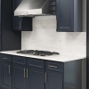 Millennium Blue kitchen cabinets with brass hardware, marble backsplash and a stainless hood
