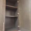 Dark Grey wall cabinet shown open with adjustable shelves and six-way soft-close hinges