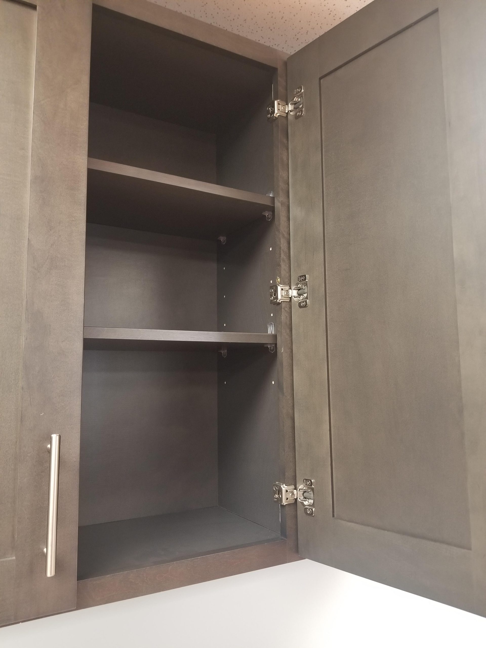 Dark Grey wall cabinet shown open with adjustable shelves and six-way soft-close hinges