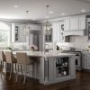 Millennium Off White kitchen cabinets with a large island, arched window and pendant lighting