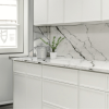 Mini White Shaker kitchen cabinets with a white marble backsplash and quartz countertop