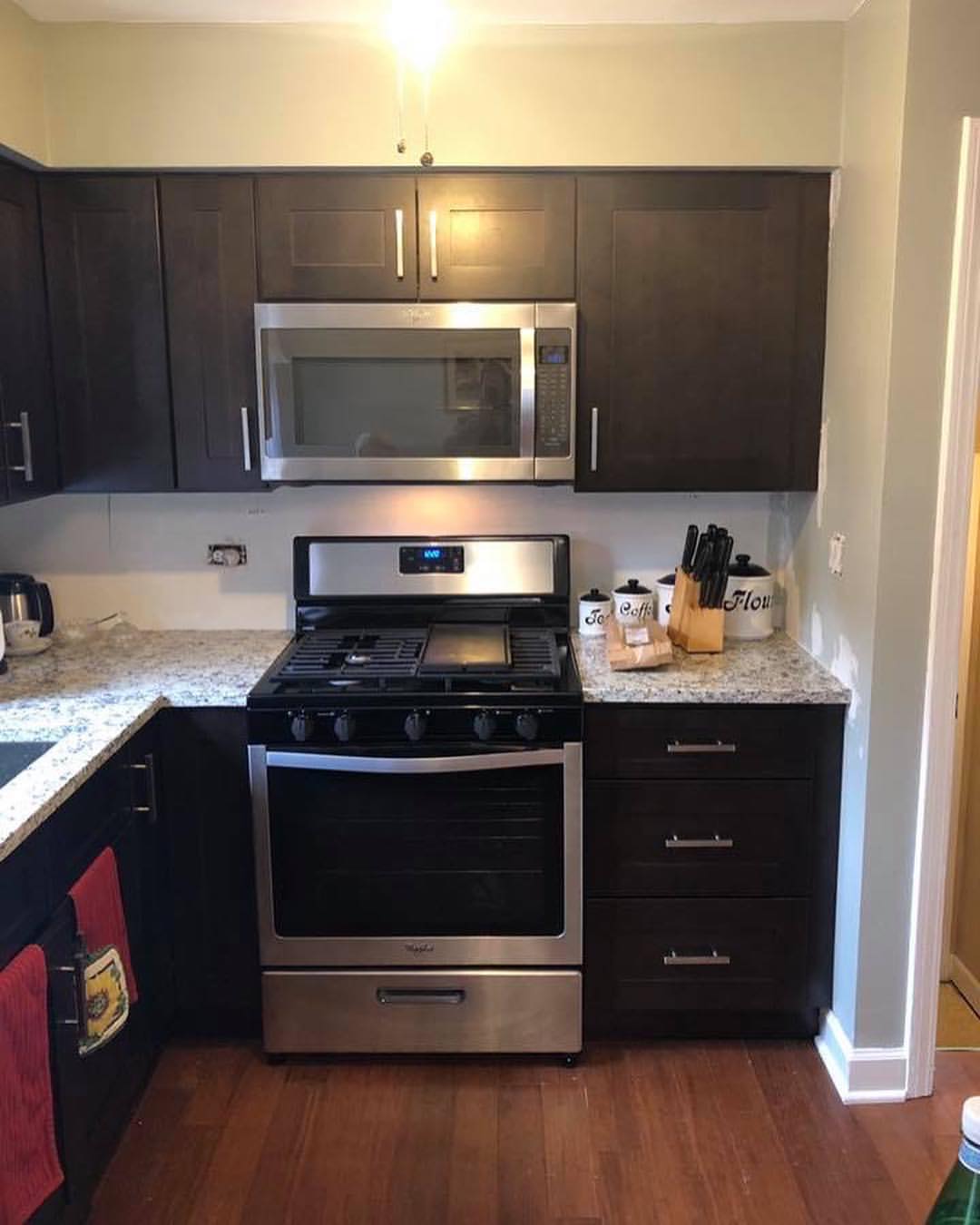 Espresso Shaker kitchen cabinets with a stainless range and granite countertop