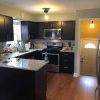 Espresso Shaker kitchen cabinets in a galley layout with granite countertops and hardwood floor