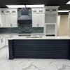 Millennium Blue kitchen island with white perimeter cabinets and a stainless range hood