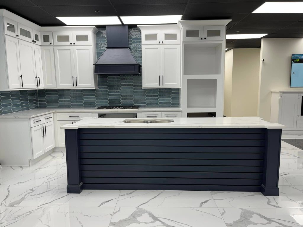 Millennium Blue kitchen island with white perimeter cabinets and a stainless range hood