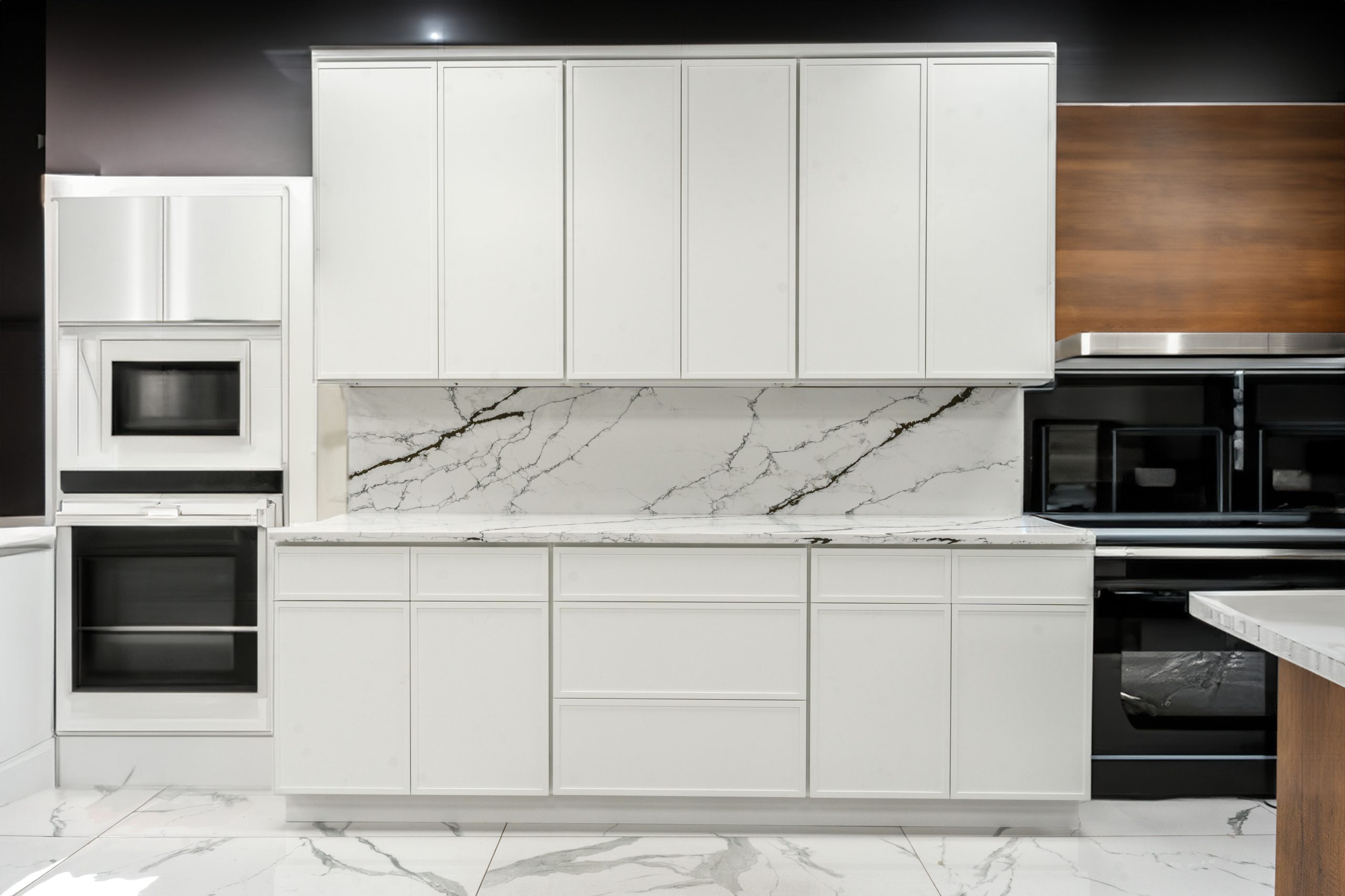 Mini White Shaker kitchen cabinets with a marble backsplash and built-in wall oven