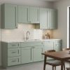 Matcha Latte sage green kitchen cabinets with a white subway tile backsplash and wood dining table