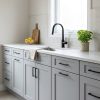 Light Grey kitchen cabinets by CCC Cabinets shown in a sink run beneath a bright window - flat shaker door in a cool neutral light grey, wholesale cabinetry in Des Plaines, Chicagoland