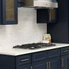 Millennium Blue kitchen cabinets with a gold mesh cabinet insert and marble countertop
