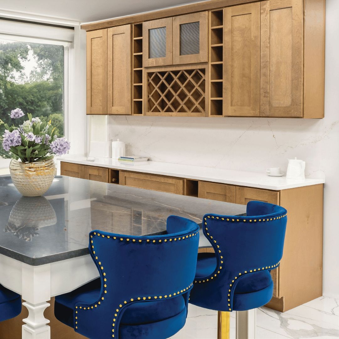 Cappuccino kitchen cabinets with a wine rack, grey island and blue velvet bar stools
