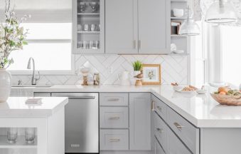 Light Grey kitchen cabinets with glass-front upper cabinets and a farmhouse sink