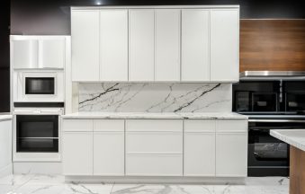 Mini White Shaker kitchen cabinets with a marble backsplash and built-in wall oven