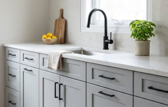 Light Grey kitchen cabinets by CCC Cabinets shown in a sink run beneath a bright window - flat shaker door in a cool neutral light grey, wholesale cabinetry in Des Plaines, Chicagoland